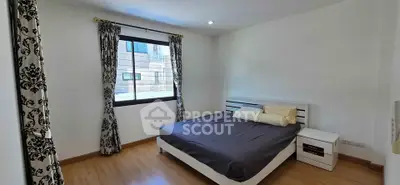 Spacious bedroom with modern decor and large window for natural light