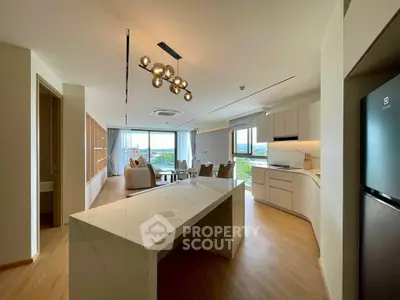 Modern open-layout kitchen and living room with elegant lighting and scenic view.