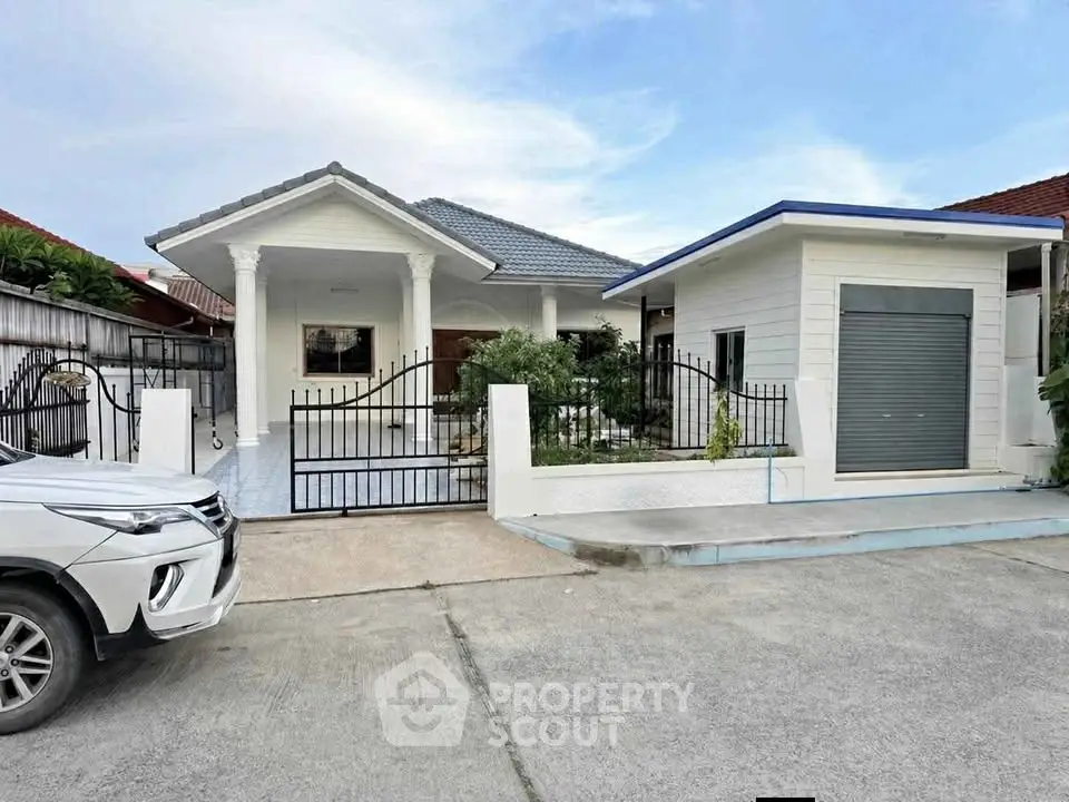 Charming single-story house with gated driveway and modern exterior design.