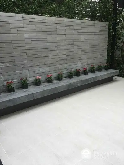 Modern minimalist garden with stone wall and potted plants