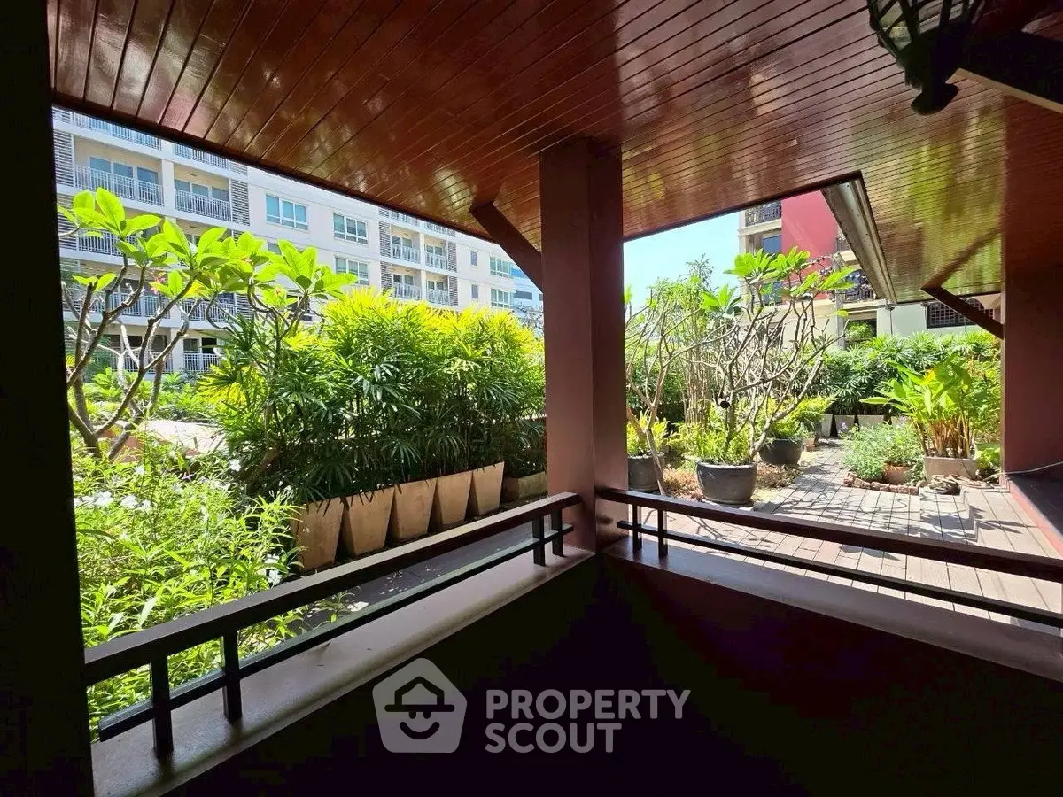 Charming garden view from a covered balcony in a modern residential complex.