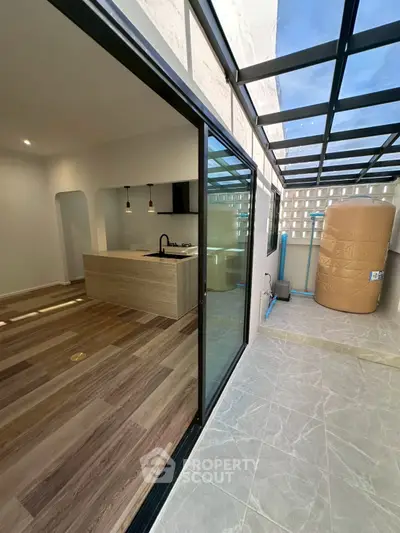 Modern kitchen with open layout and adjacent outdoor space featuring a water tank.