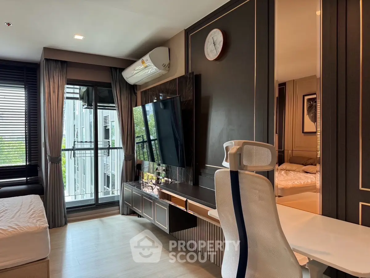 Modern living room with sleek design, large TV, and balcony access in a stylish apartment.