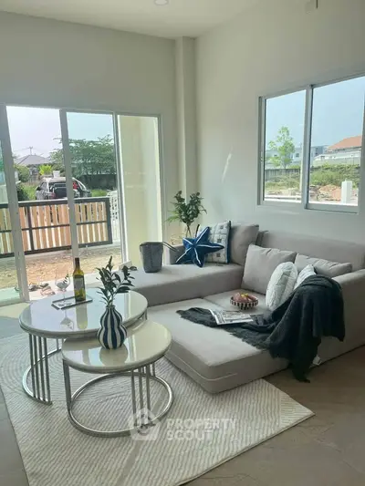 Modern living room with large windows and stylish decor in a bright, open space.