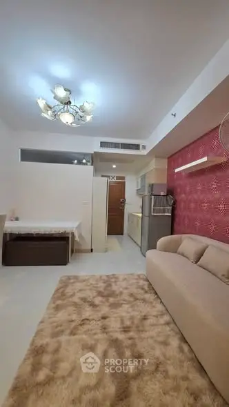 Modern living room with elegant chandelier and cozy beige sofa in stylish apartment.