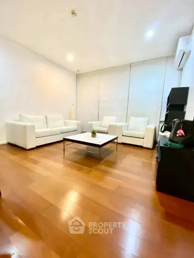 Spacious modern living room with elegant white sofas and wooden flooring