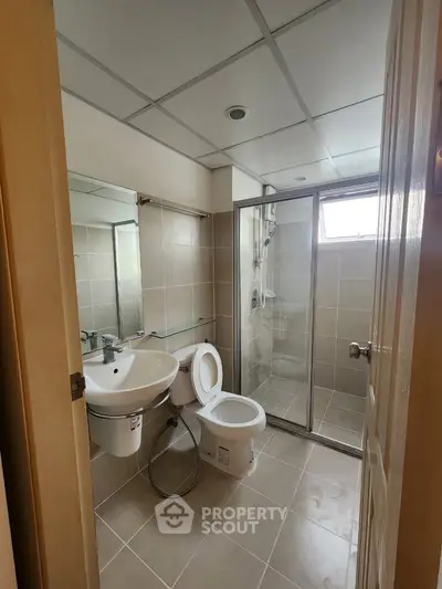 Modern bathroom with glass shower and sleek fixtures in a contemporary home.