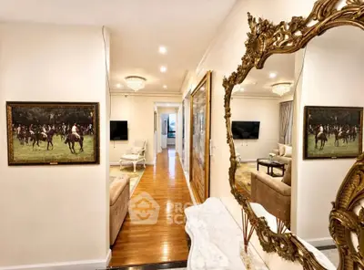 Luxurious hallway with elegant decor and ornate mirror reflecting a spacious living area.