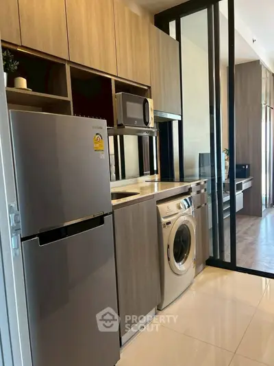 Modern kitchen with sleek appliances and stylish cabinetry in a contemporary apartment.