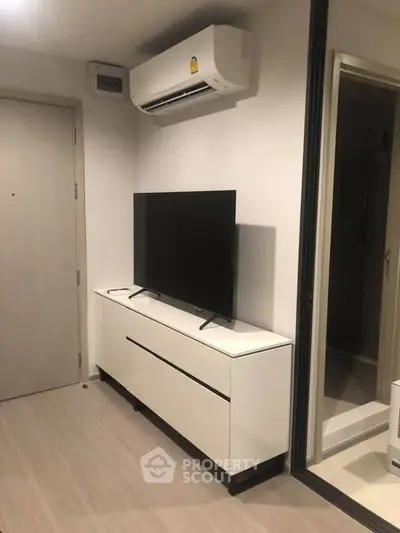 Modern living room with sleek TV stand and air conditioning unit, perfect for urban living.