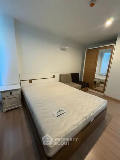 Cozy bedroom with modern furnishings and ample natural light, featuring a comfortable bed and stylish wardrobe.