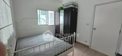 Cozy bedroom with elegant metal bed frame and spacious wardrobe, perfect for modern living.