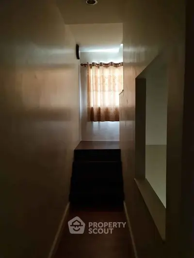 Cozy hallway with natural light and window curtains in a residential property.