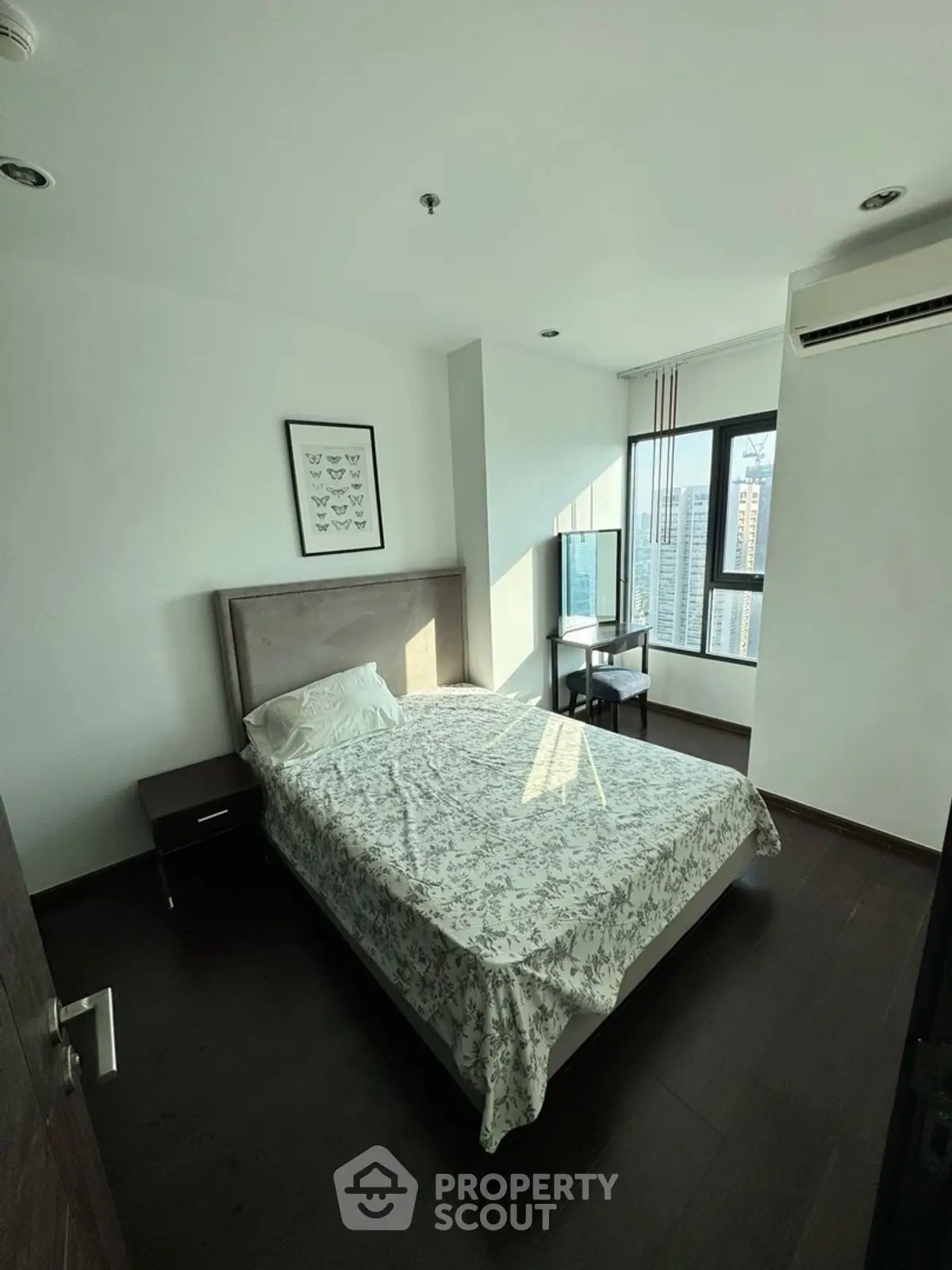 Modern bedroom with city view, featuring sleek design and natural light, perfect for urban living.