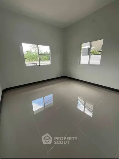 Spacious empty room with large windows and glossy tiled floor, perfect for customization.