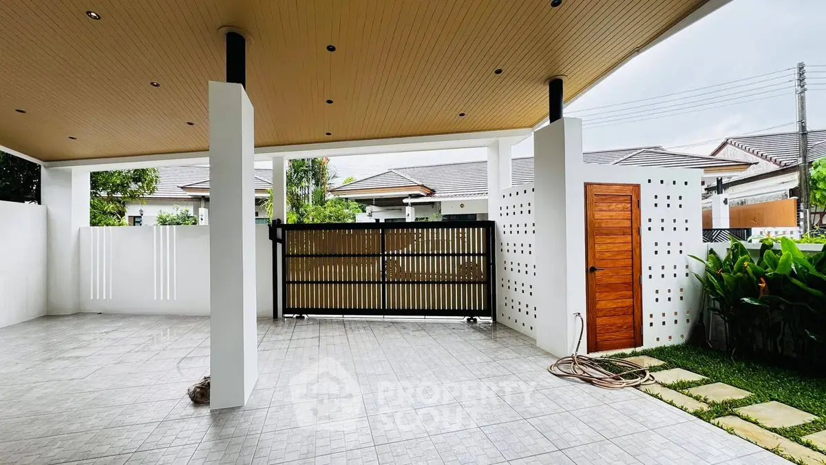 Spacious covered patio with modern design and garden view in a suburban home.
