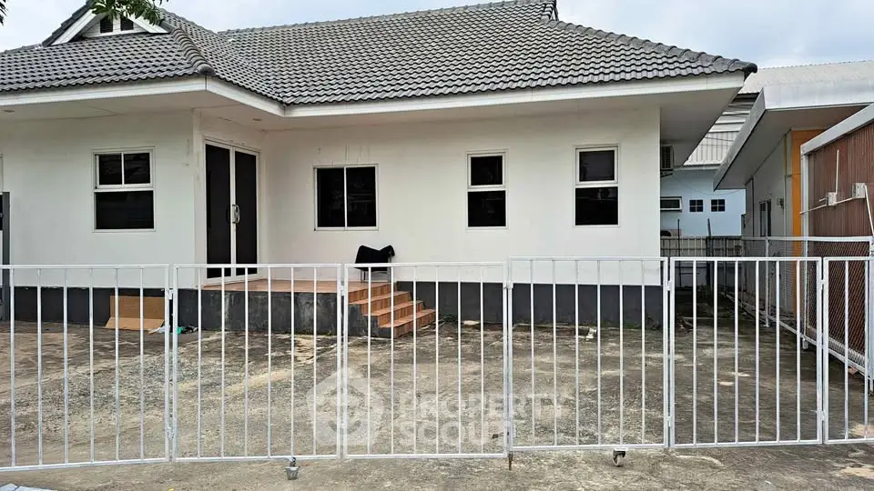 Charming single-story house with tiled roof and fenced front yard