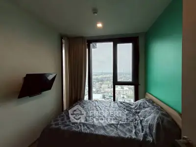 Cozy bedroom with city view and wall-mounted TV in modern apartment.