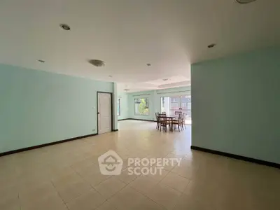 Spacious open-plan living area with dining set and large windows