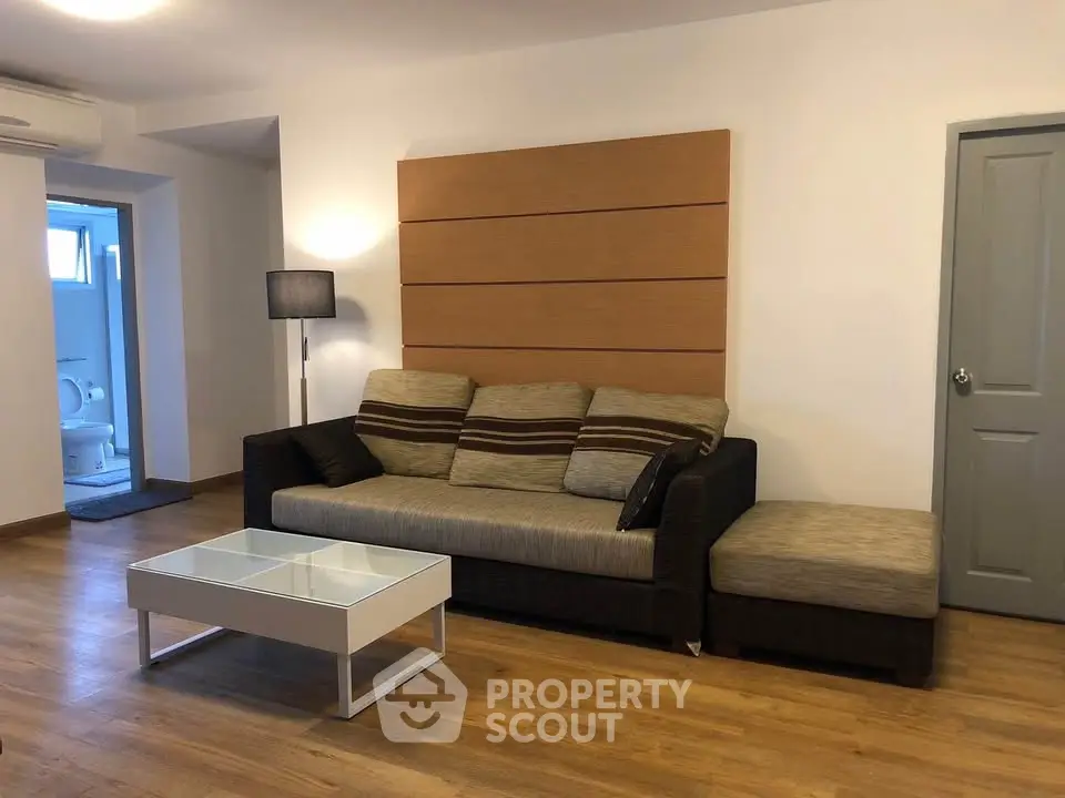Spacious living room with modern sofa and stylish decor in a cozy apartment.