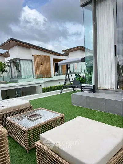 Luxurious modern terrace with stylish outdoor furniture and scenic view of contemporary villas.