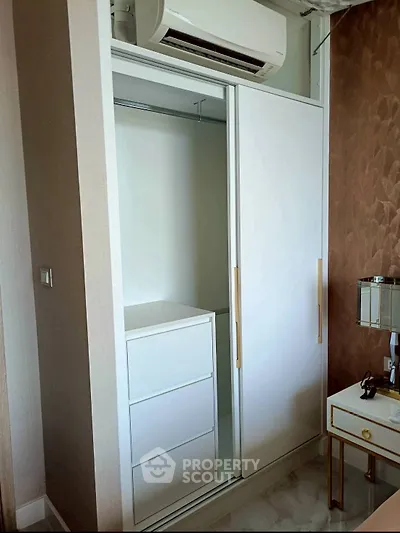 Modern bedroom with sleek white wardrobe and air conditioning unit