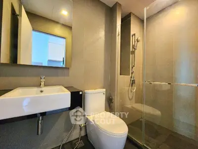 Modern bathroom with sleek design featuring a glass shower and contemporary fixtures.