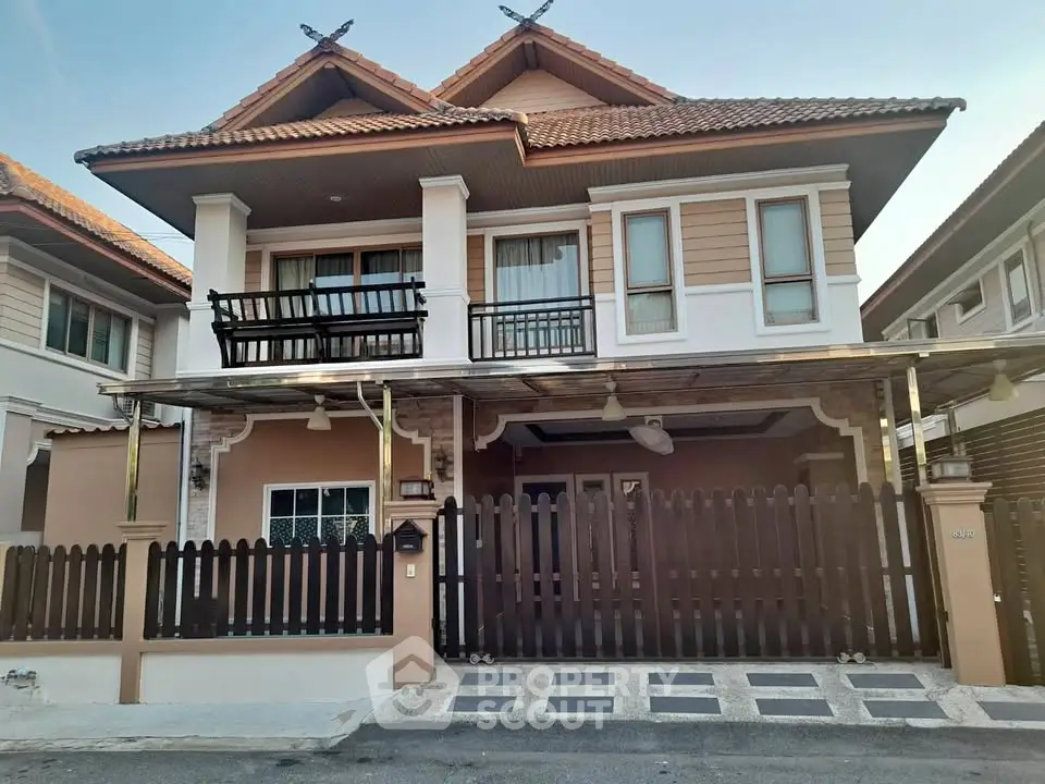 Charming two-story house with a fenced yard and tiled roof in a suburban neighborhood.
