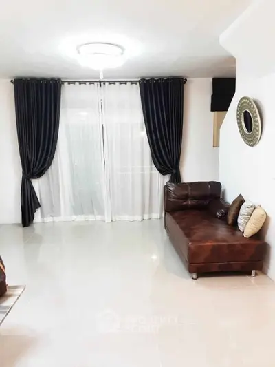 Spacious living room with elegant curtains and leather sofa