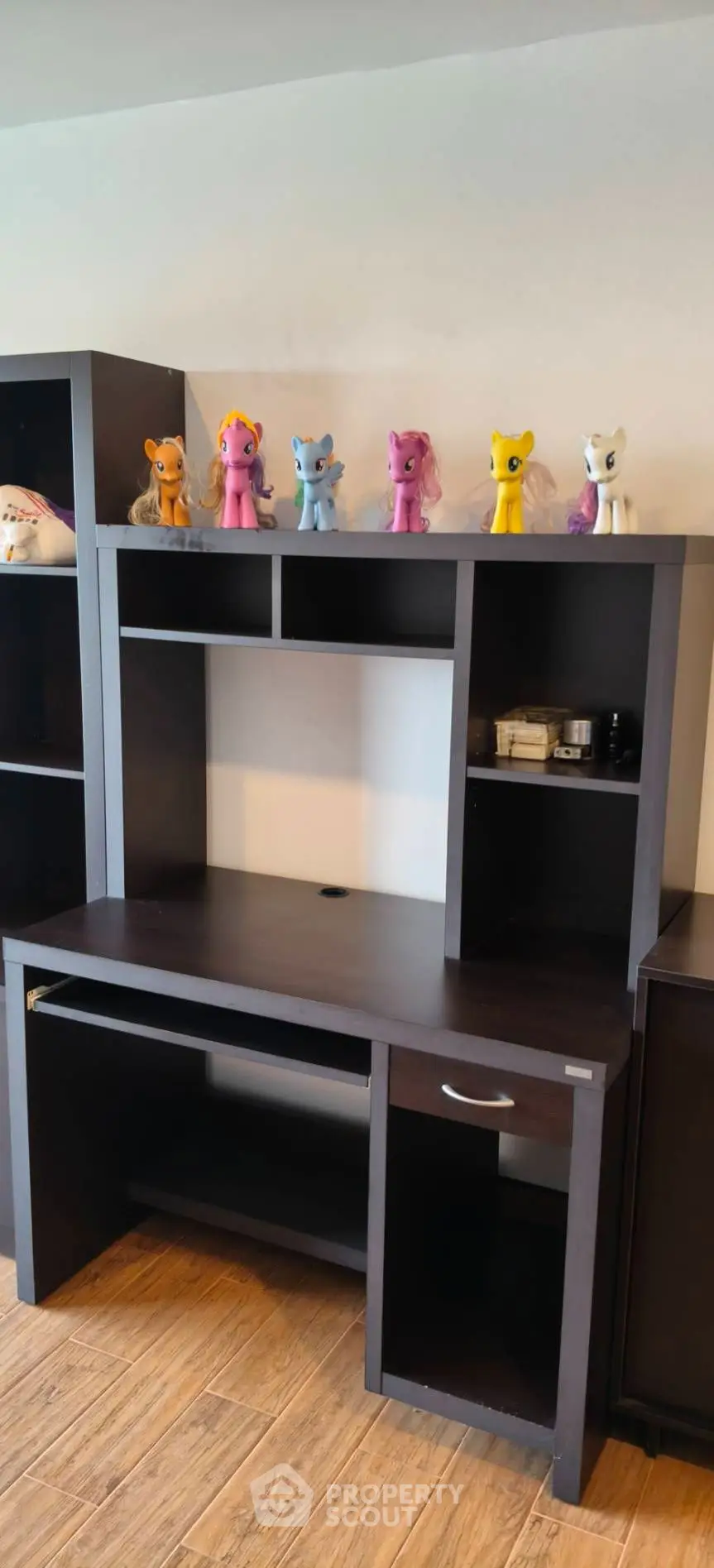 Spacious study area with dark wood desk and shelves, perfect for home office setup.