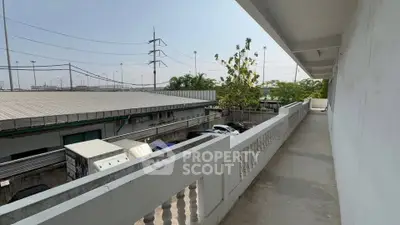 Spacious balcony with industrial view and ample sunlight, perfect for outdoor relaxation.