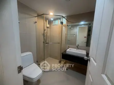 Modern bathroom with glass shower and sleek fixtures in a contemporary home.