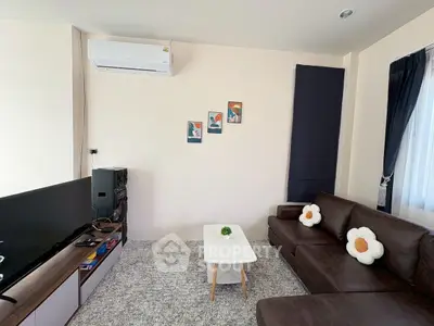 Charming living room with cozy brown sofa, modern decor, and wall-mounted air conditioner.