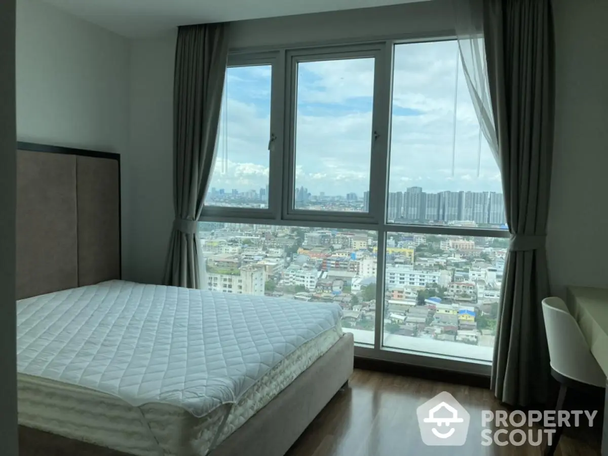 Spacious bedroom with stunning city view from large windows, modern decor and natural light.