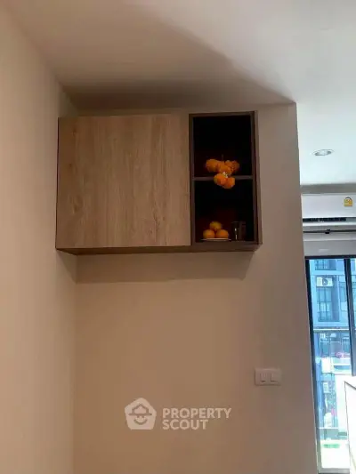 Modern kitchen cabinet with open shelving and decorative items in a stylish apartment.