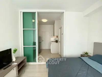 Modern studio apartment with sliding glass doors and compact kitchen