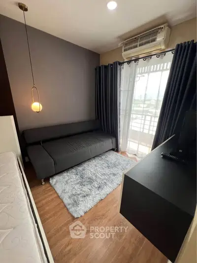 Modern living room with sleek furniture and balcony view in stylish apartment.