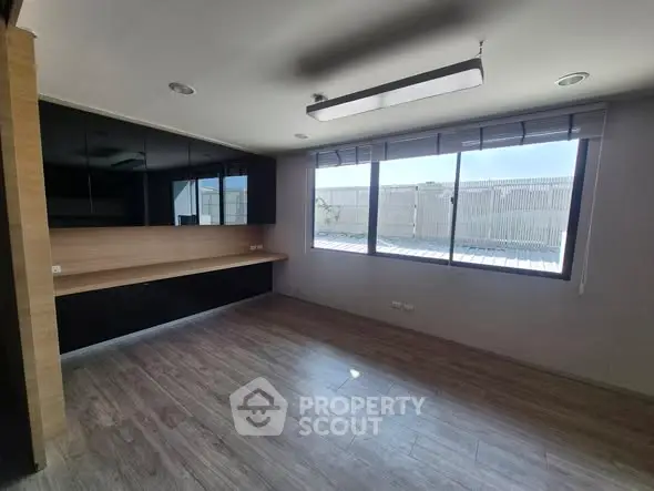 Spacious modern study room with large windows and sleek wooden flooring.