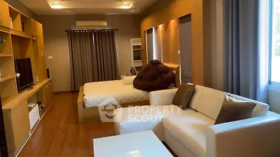 Spacious studio with modern decor, cozy bed, and stylish living area.