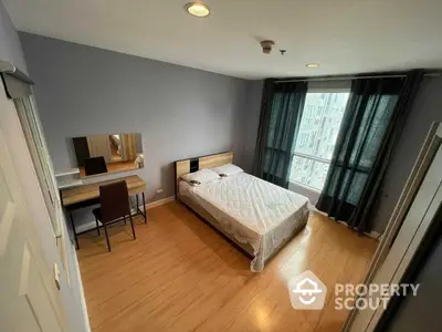 Spacious bedroom with polished hardwood floors, large windows offering ample natural light, and a modern aesthetic, perfect for relaxation and comfort.