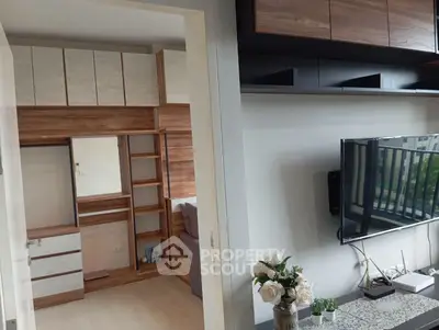 Modern living room with stylish wooden cabinetry and wall-mounted TV, featuring elegant decor and natural light.