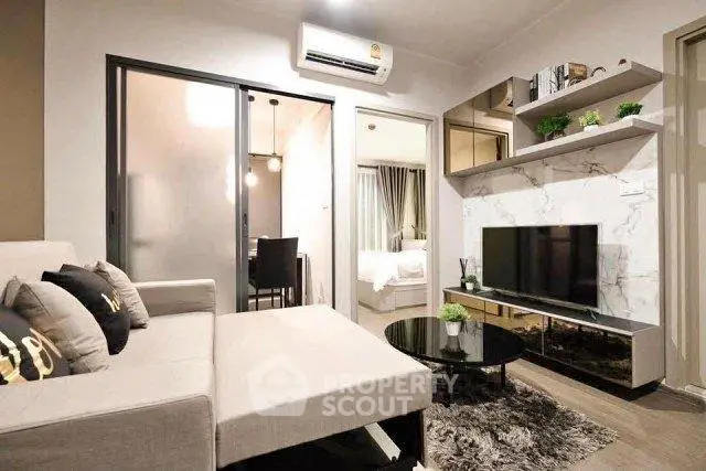 Modern living room with stylish decor and open layout, featuring a cozy sofa and sleek TV setup.