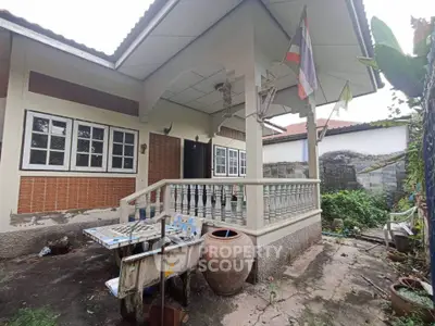 Charming single-story home with a cozy porch and lush garden, perfect for serene living.