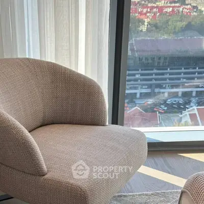 Modern apartment with cozy armchair and panoramic city view.