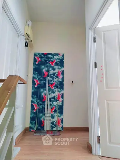 Charming hallway with vibrant bird-themed curtain and wooden staircase