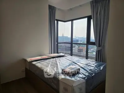 Modern bedroom with large windows offering stunning city views