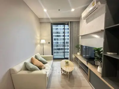 Modern living room with balcony view, stylish furniture, and natural light in a contemporary apartment.