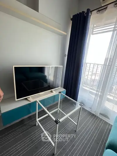 Modern living room with sleek TV setup and balcony view