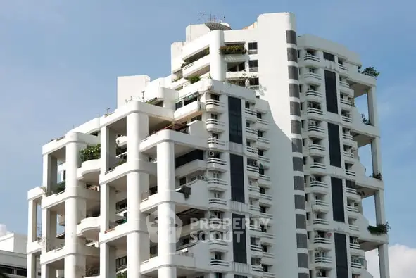 Modern high-rise building with unique architectural design and spacious balconies.