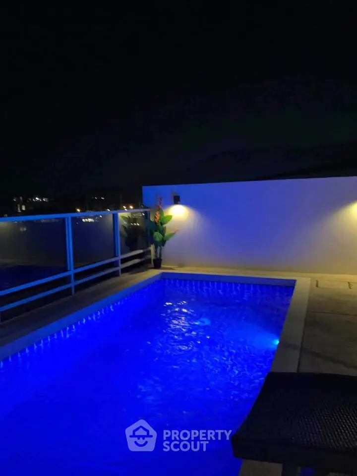 Stunning rooftop pool with ambient night lighting and modern design.